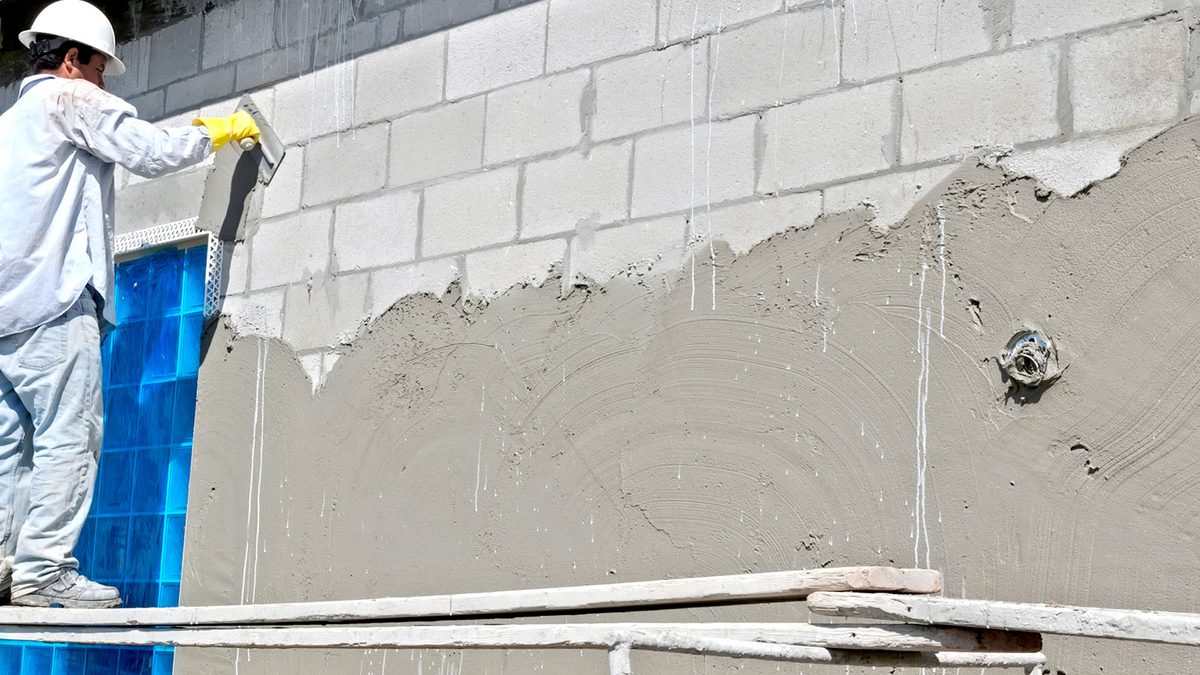 Worker applying fresh stucco to an exterior wall